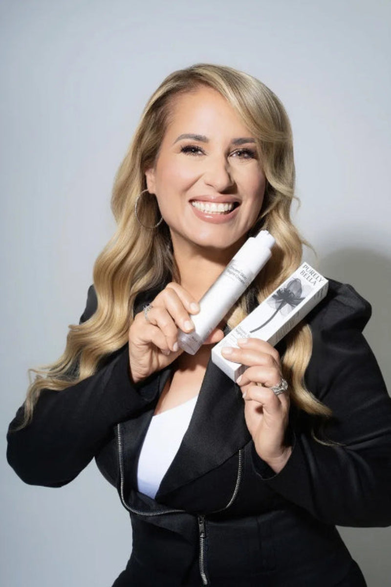Woman holding a white hair product against a gray background