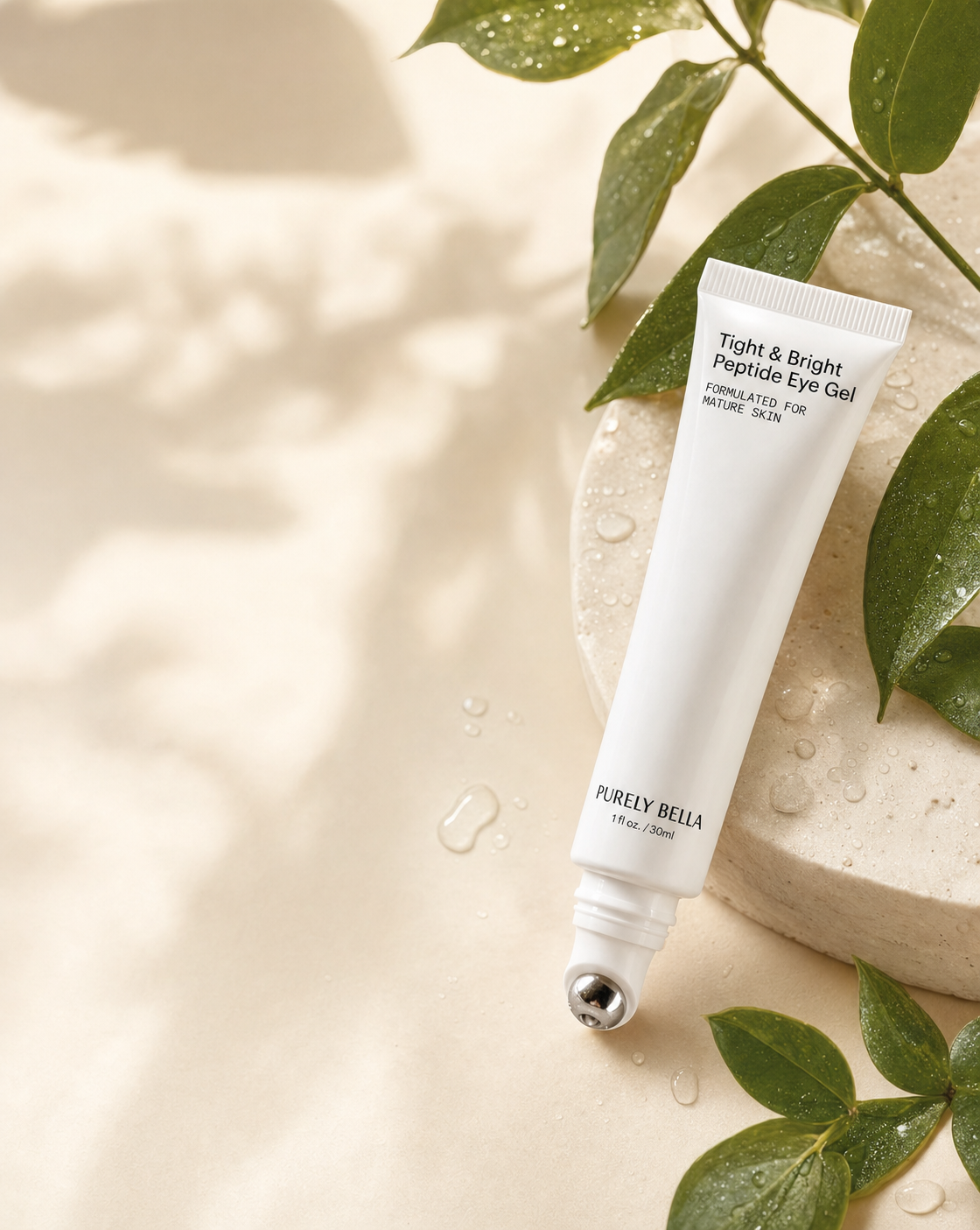 Purely Bella Tight & Bright Peptide Eye Gel with cool metal applicator resting on a warm neutral surface with dewy botanicals
