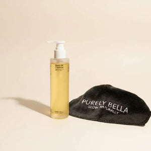 Bottle of skincare product and black towel with 'Purely Bella' branding on a white background
