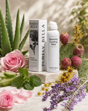 Purely Bella Serenity Cooling Mist with packaging surrounded by flowers and plants on a light surface.