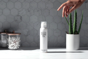 hand picking up serenity cooling mist in a bathroom