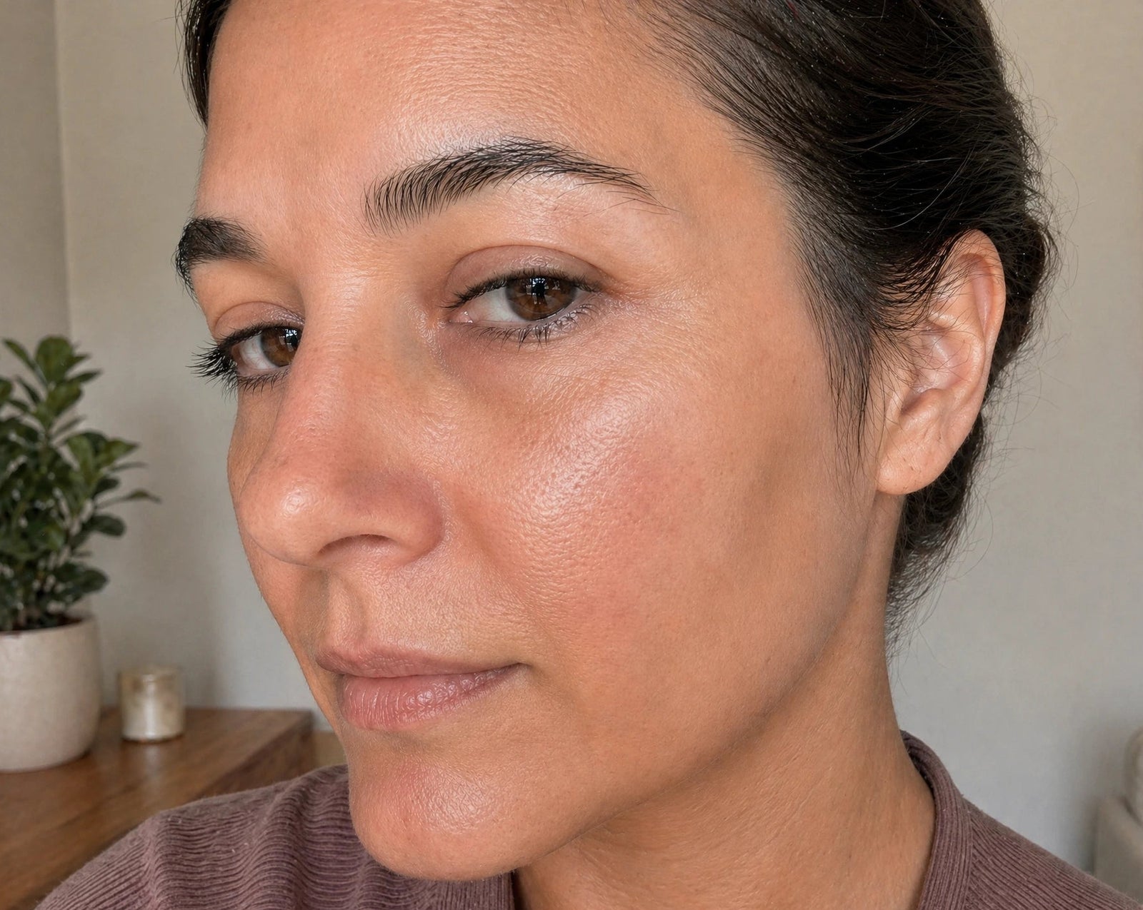 Close-up of a woman's face with a neutral expression, indoors.