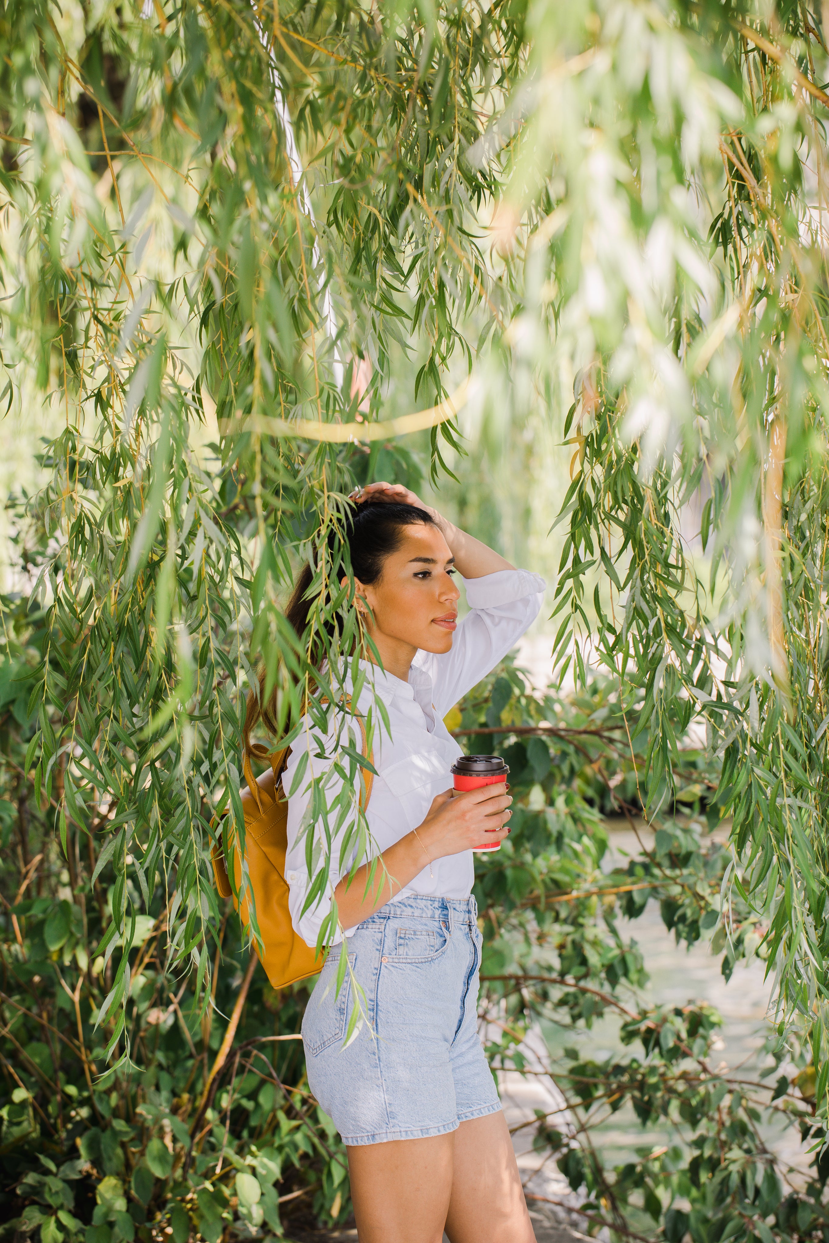 person-stands-surrounded-by-willow-tree-leaves.jpg