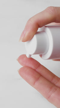 Dream Skin Night Cream Astaxanthin powered pumping on a woman's hand.